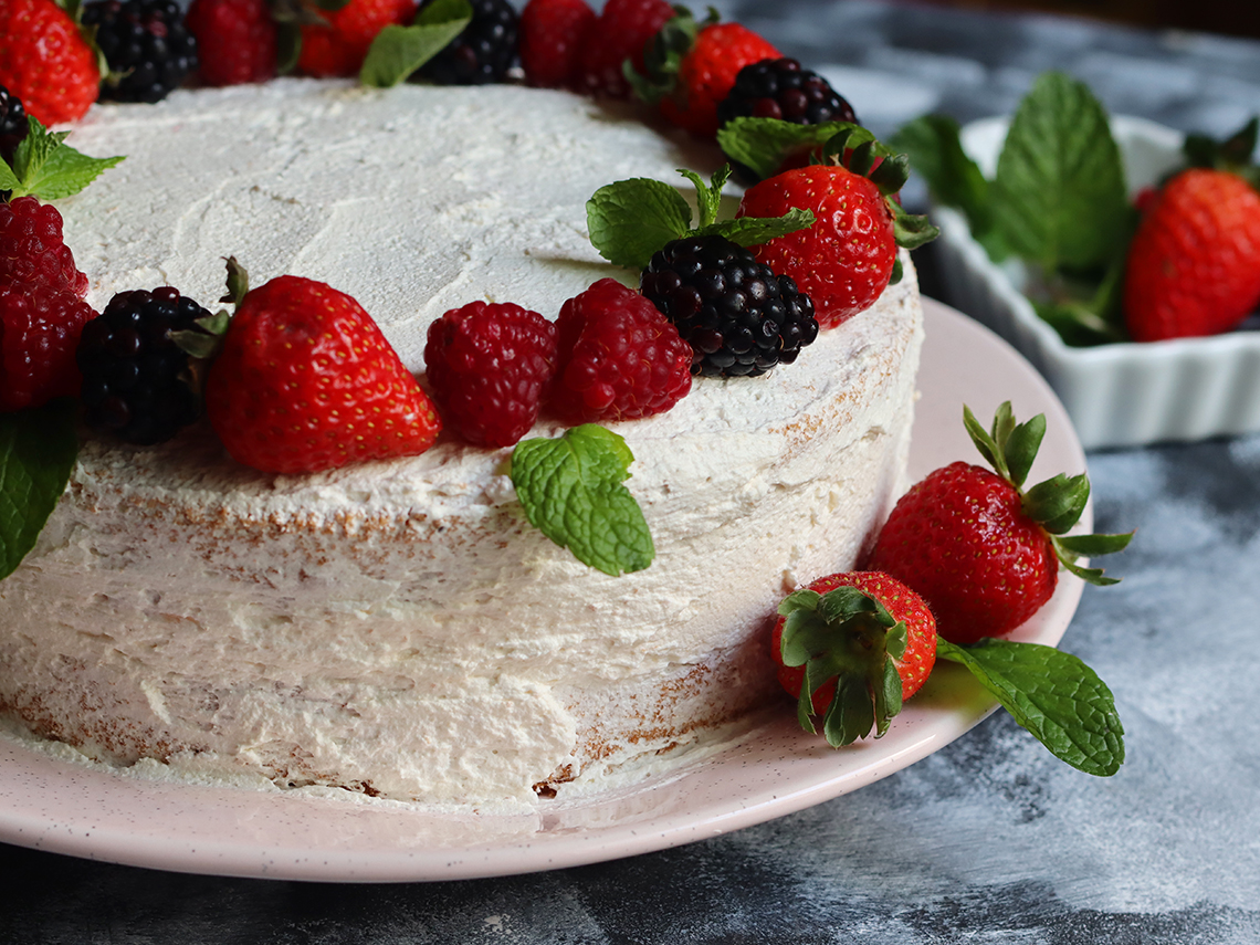 bolo com rosetas de chantilly e morangos