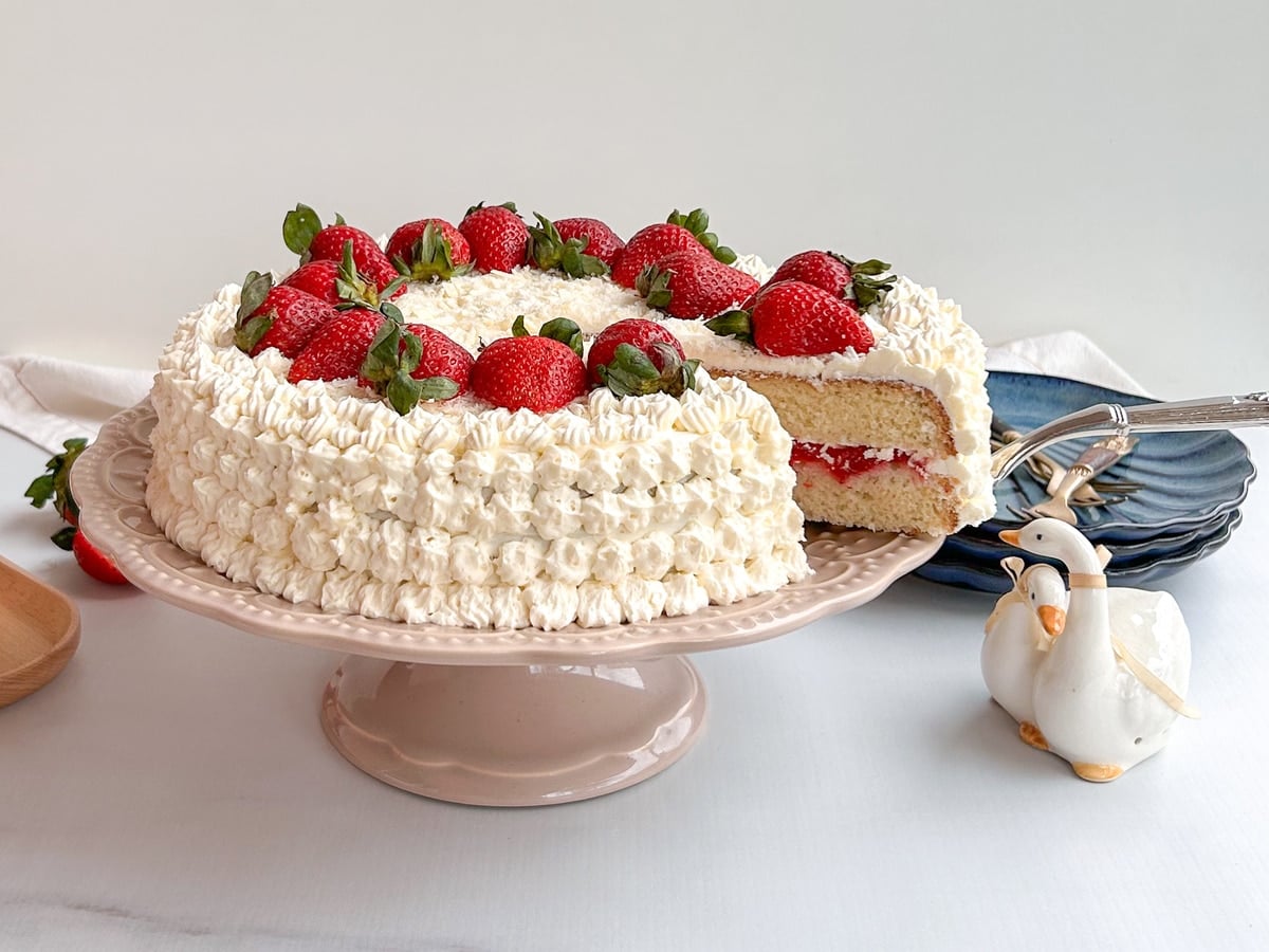 bolo com rosetas de chantilly e morangos