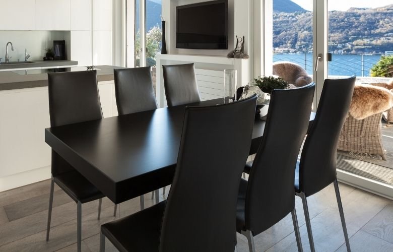 mesa de jantar preta com cadeiras caramelo